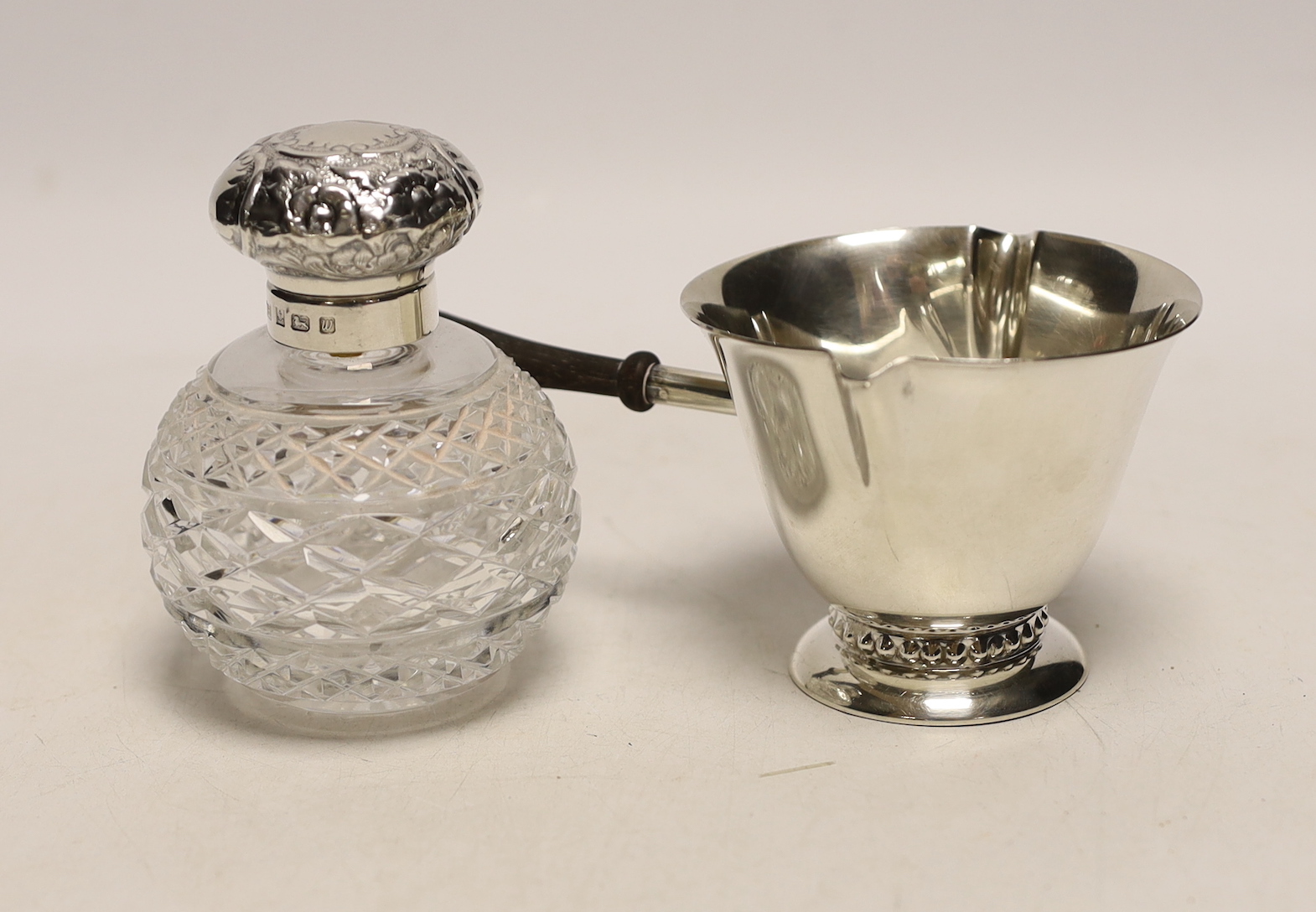 A sterling double lipped pan with turned wooden handle, 17.5cm and a modern silver mounted cut glass scent bottle.